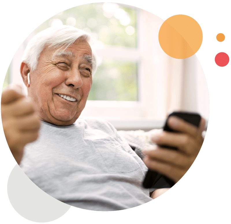Ein Senior kommuniziert mit einem Mobiltelefon und freut sich