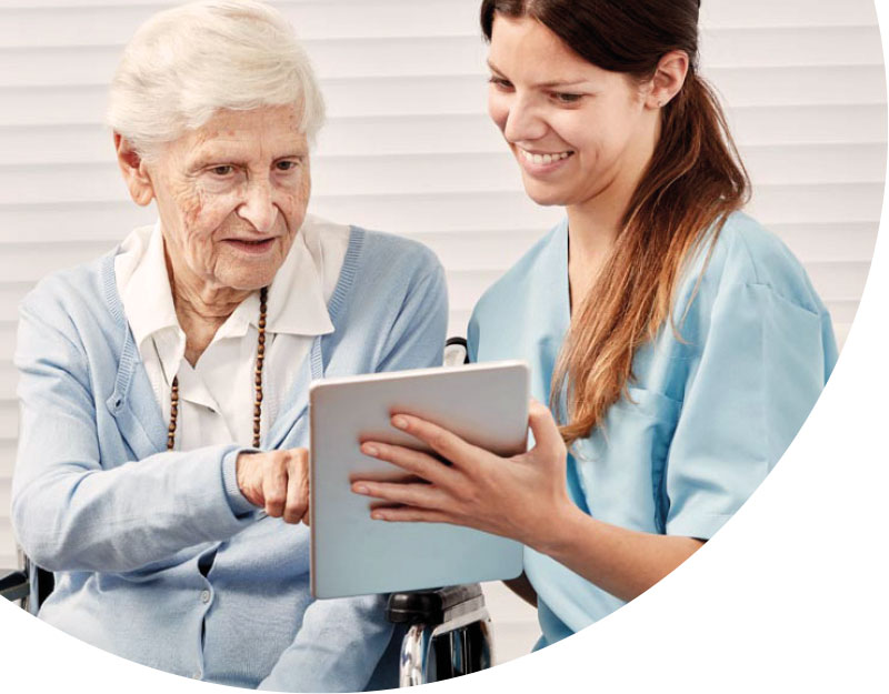 Eine Senioren im Seniorenheim kommuniziert per Tablet mit ihren Liebsten